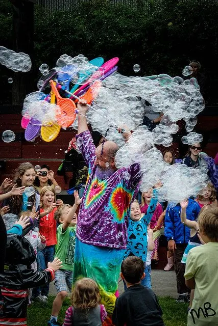 Garry raising a rainbow bubble wand over the crowd