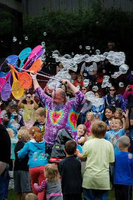 A crowd of kids under a stream of bubbles