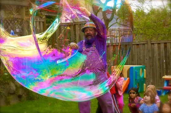 A giant rainbow bubble over a garden party