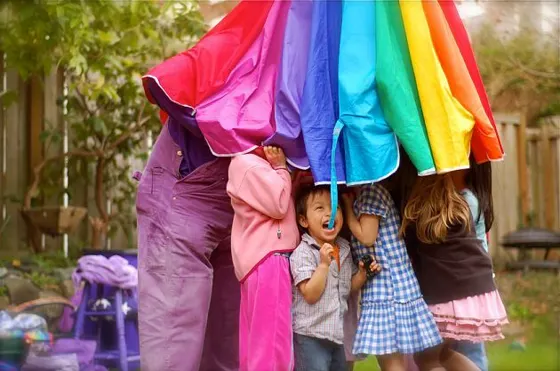 Kids under a rainbow parachute